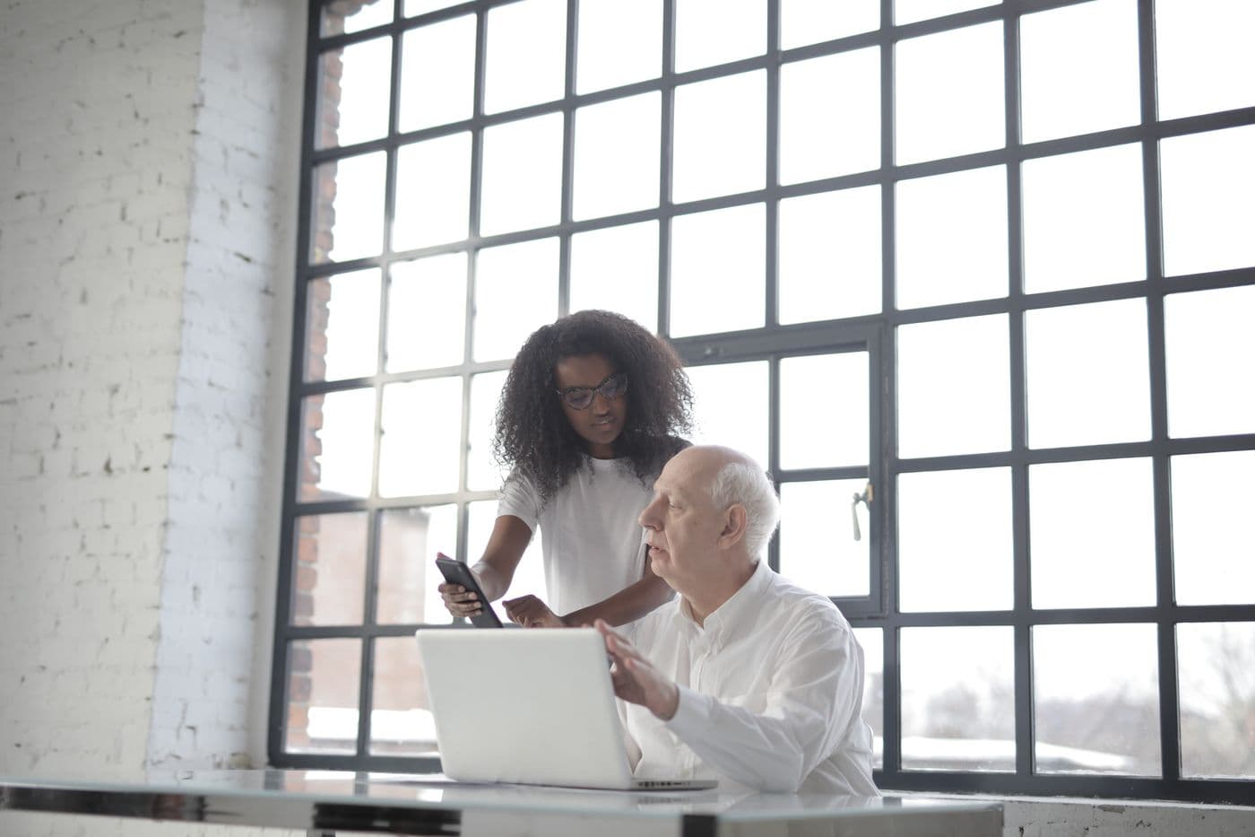 An IT consultant reviewing a laptop with a business owner