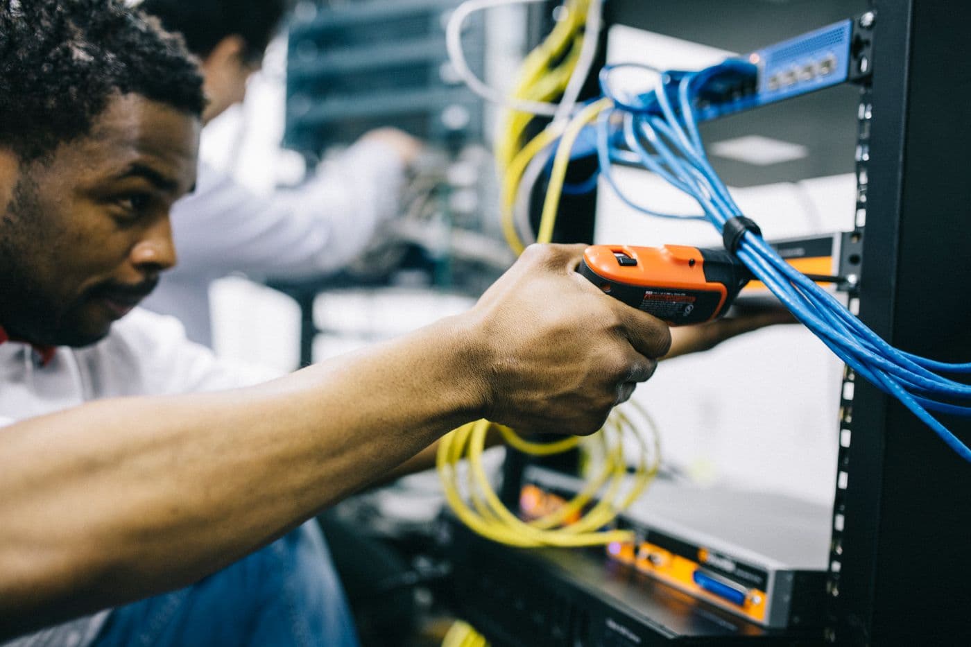 An engineer patching network cables in a server rack