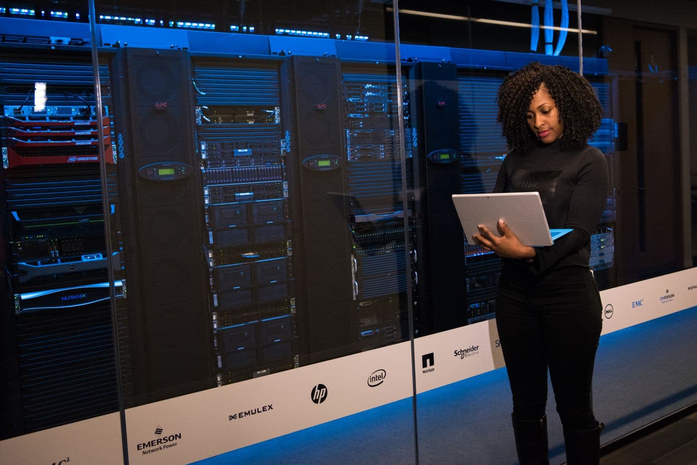 An engineer with a laptop in a data centre aisle